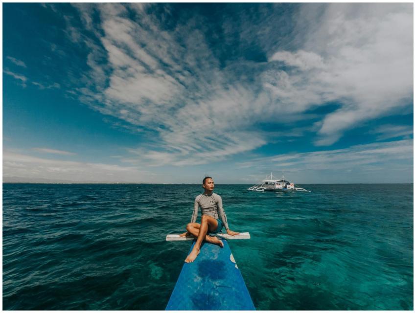 Man sitting on a boat's bow, enjoying a peaceful o