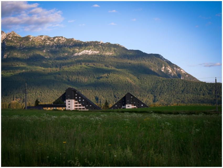 Triangular modern buildings set against rolling mo