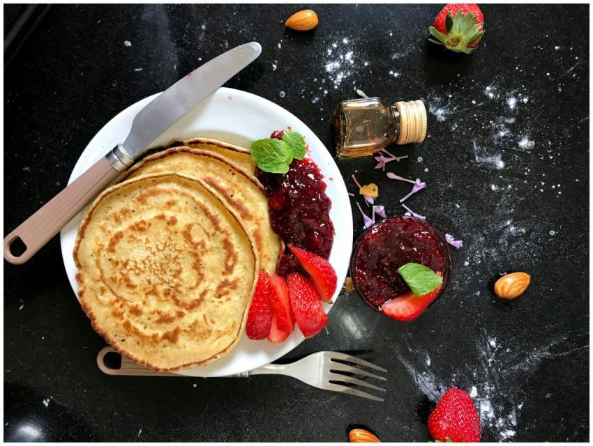 Top view of pancakes with strawberry jam, fresh st
