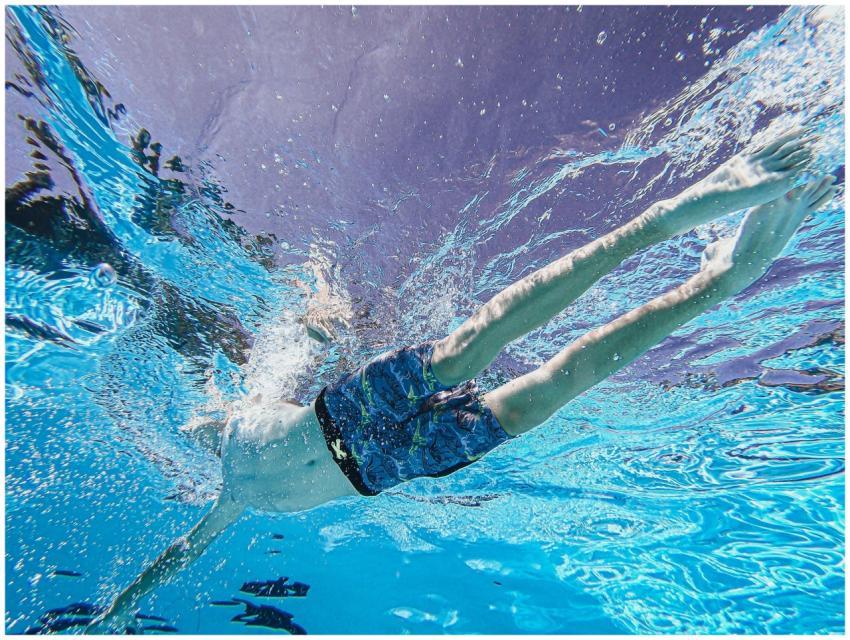 Dynamic underwater shot of a swimmer diving in a c