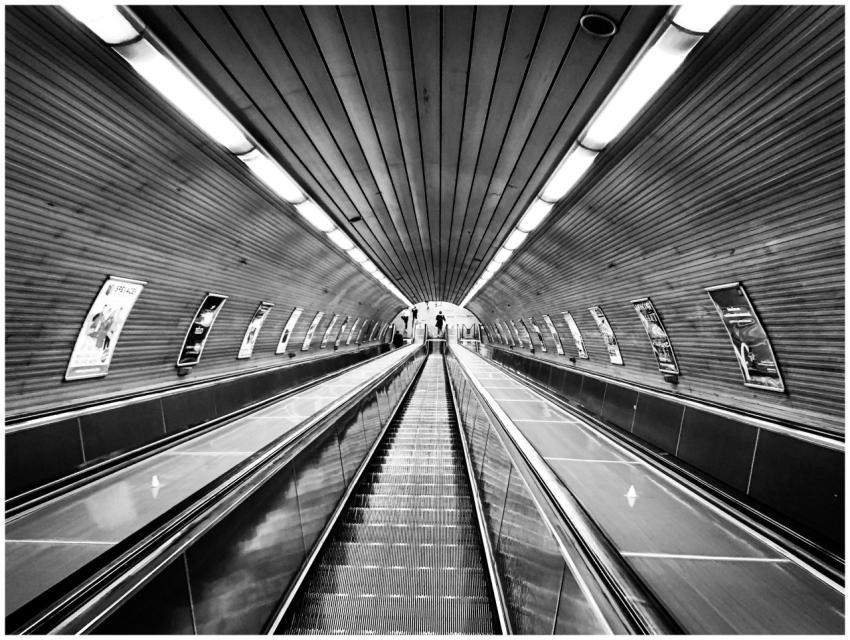 Black and white photo of an underground escalator