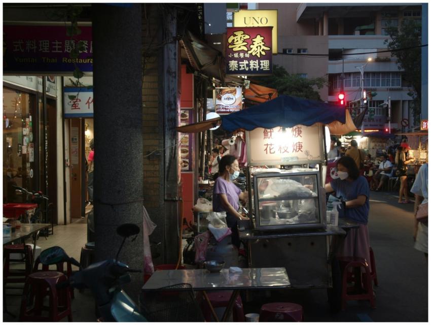 Bustling night street market scene with food stand