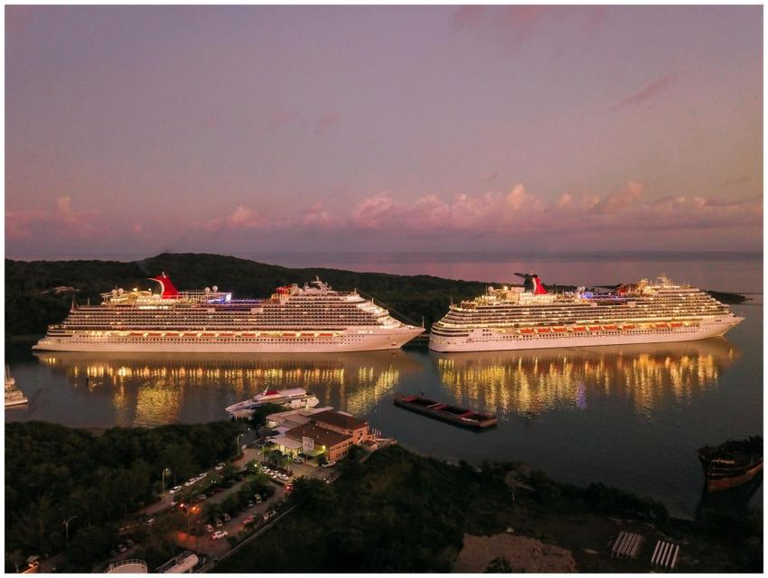 Two illuminated cruise ships docked at Coxen Hole,