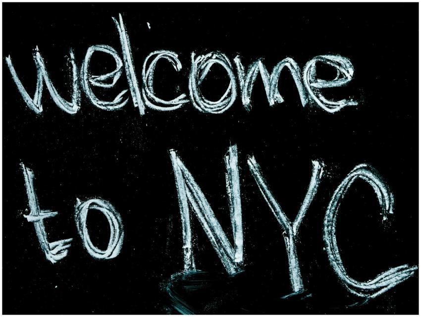 Close-up of a chalkboard with 'Welcome to NYC' han