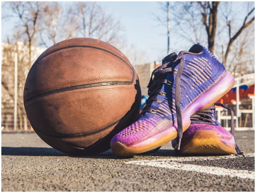 Close-up of sneakers and a basketball on an outdoo