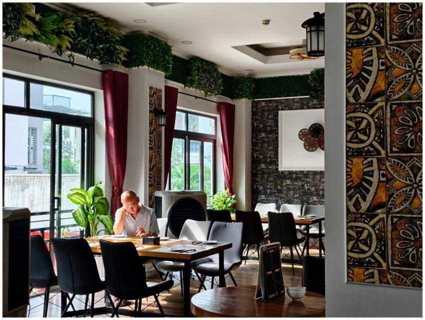 Calm restaurant setting with an adult reading and