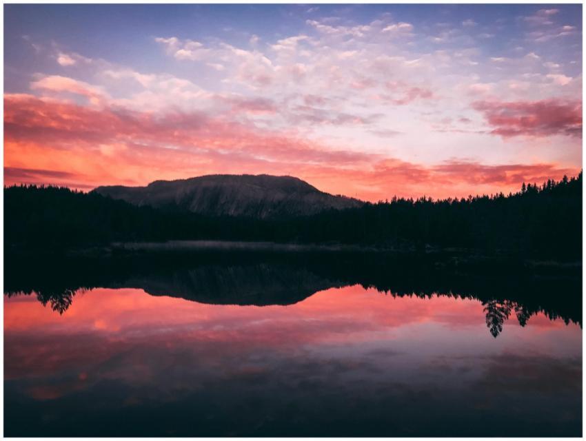 A serene sunrise over a calm lake with vivid refle
