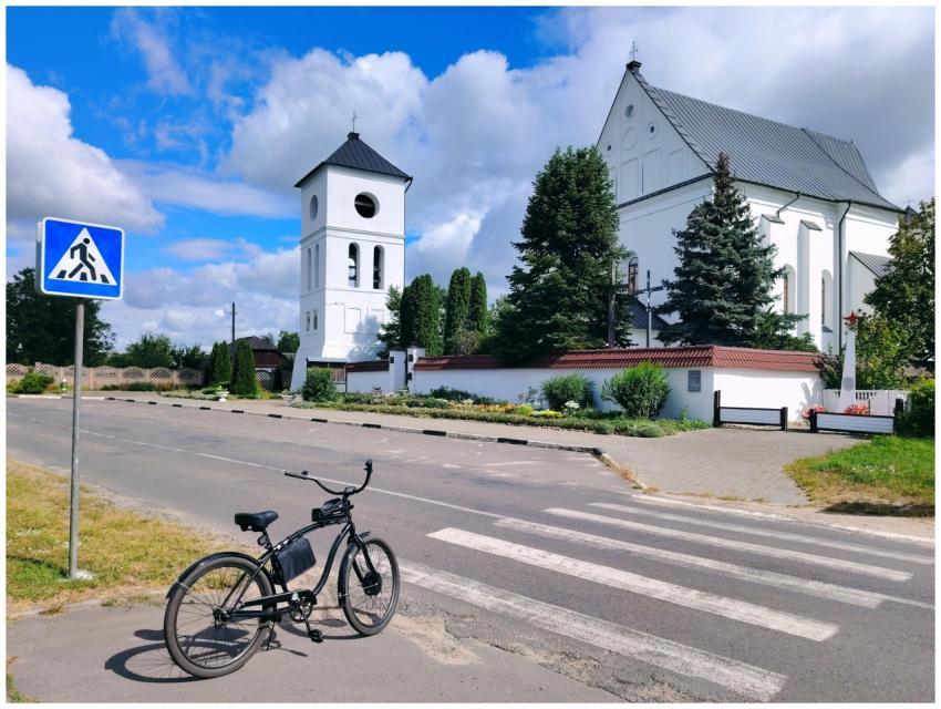 A quaint church with a bell tower, bicycle, and cr