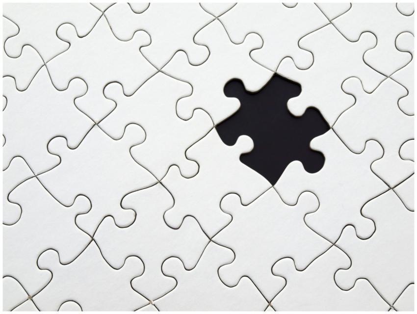 Close-up of an incomplete white puzzle with one mi