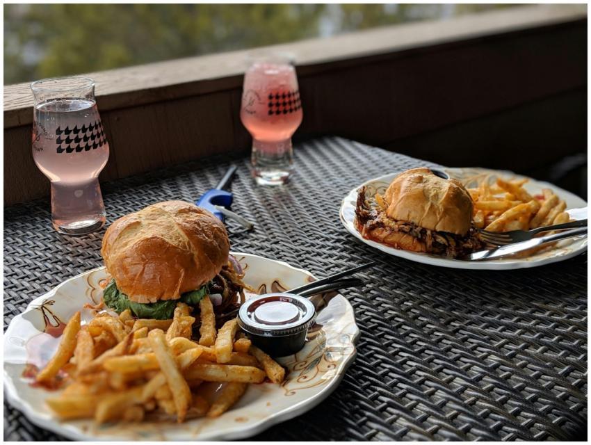 Tasty burgers with fries and pink beverages on an