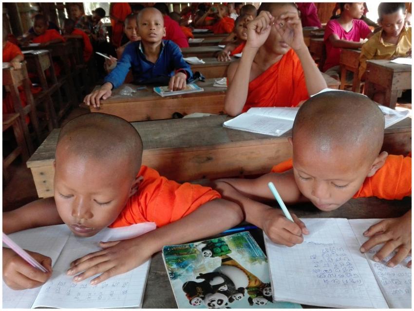 Young monks in Cambodia focus on writing in a clas