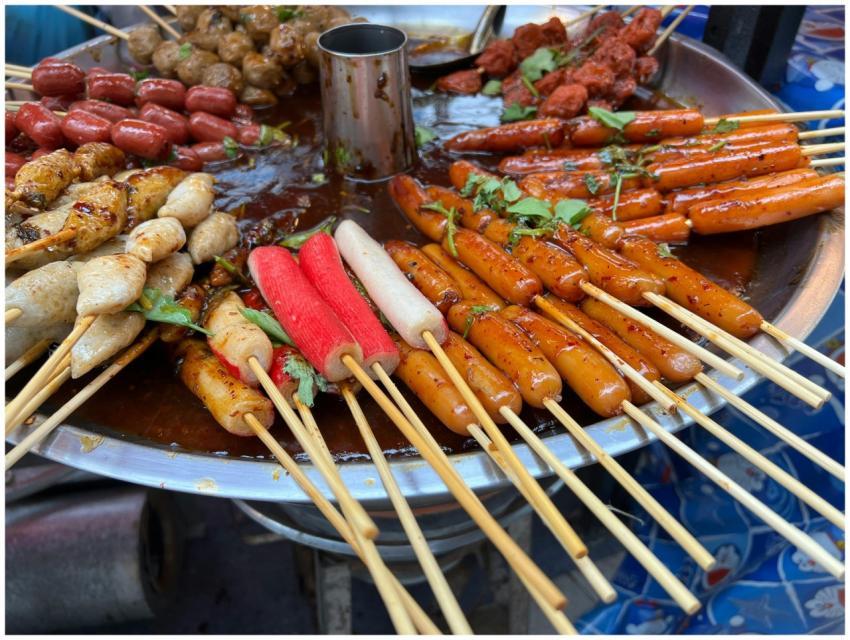 A vibrant display of various skewered street foods