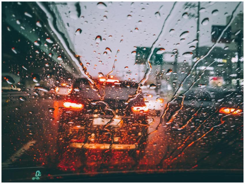 Blurred city traffic seen through a rain-soaked wi