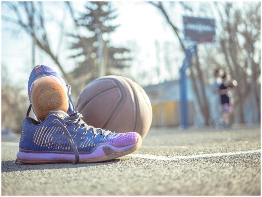 Detailed shot of sneakers next to a basketball on