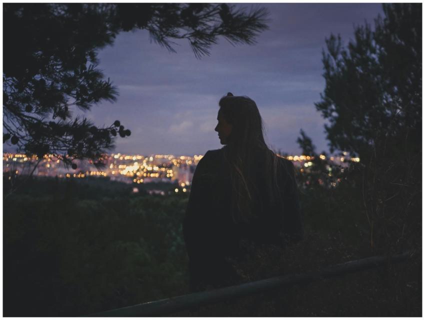A woman gazes over the illuminated Lisbon cityscap