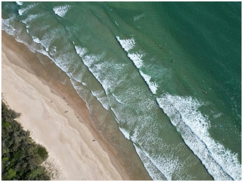 A stunning aerial shot capturing waves and sandy s
