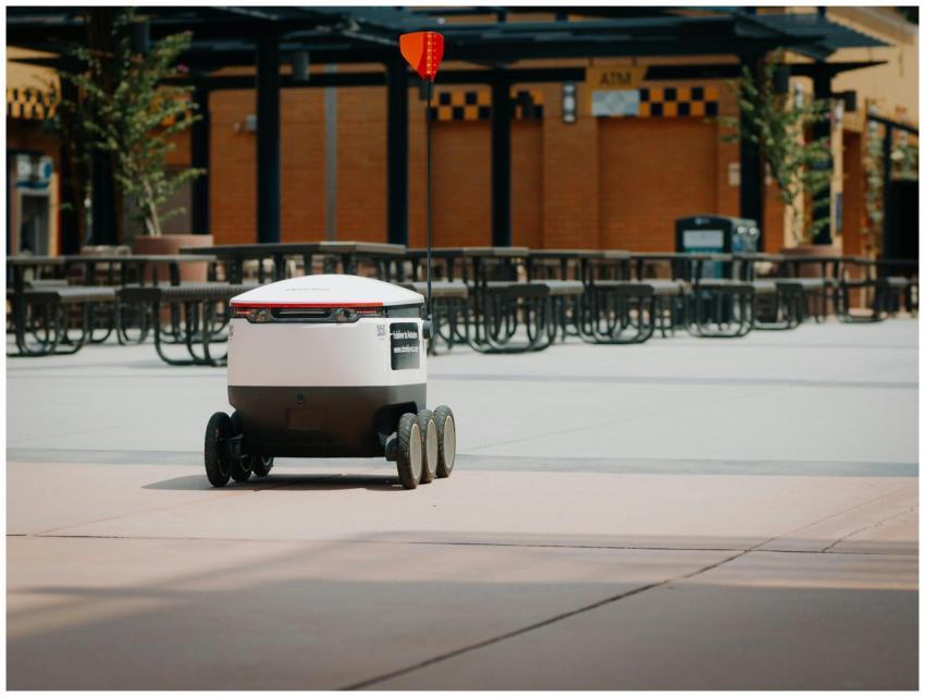 Futuristic delivery robot navigating an empty outd