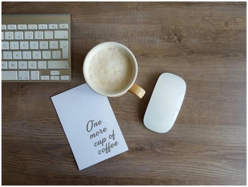 Top view of a workspace with a coffee cup, keyboar