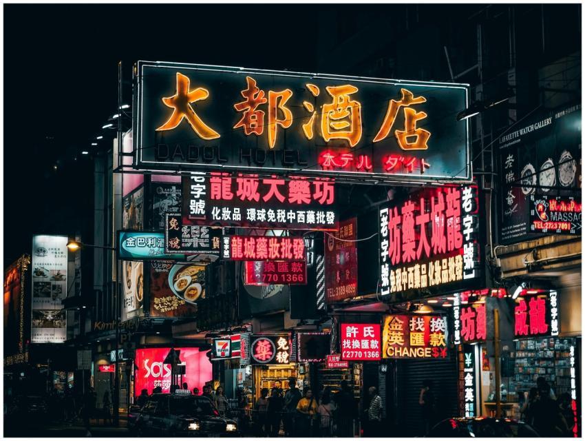 Colorful neon signs illuminate the bustling street