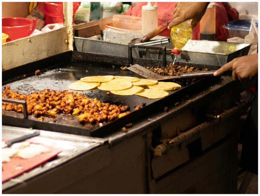 Men cooking authentic Mexican tacos at a street fo