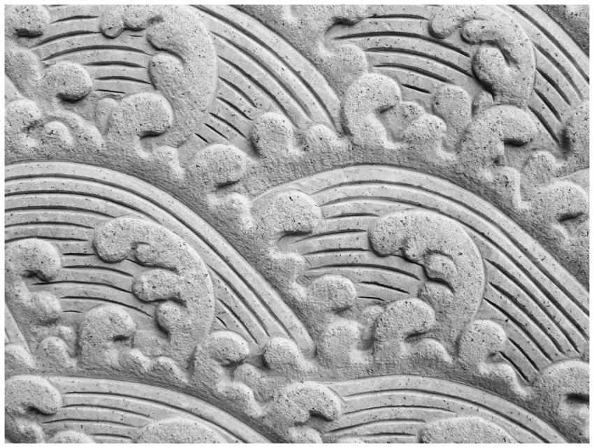 Detailed stone carving depicting elegant ocean wav
