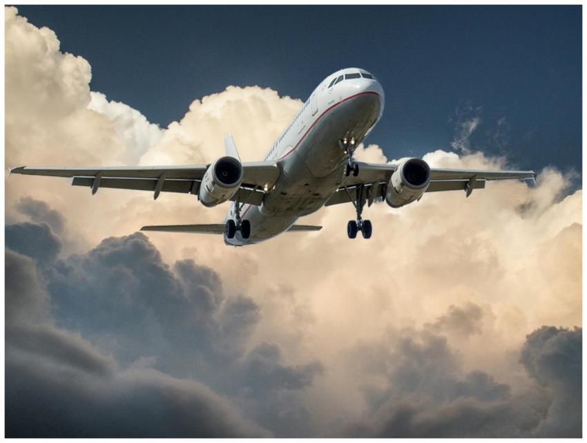 A commercial airplane flying through dramatic clou