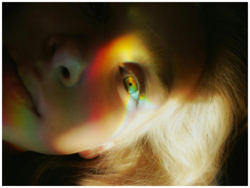 Close-up portrait of a woman with rainbow light re