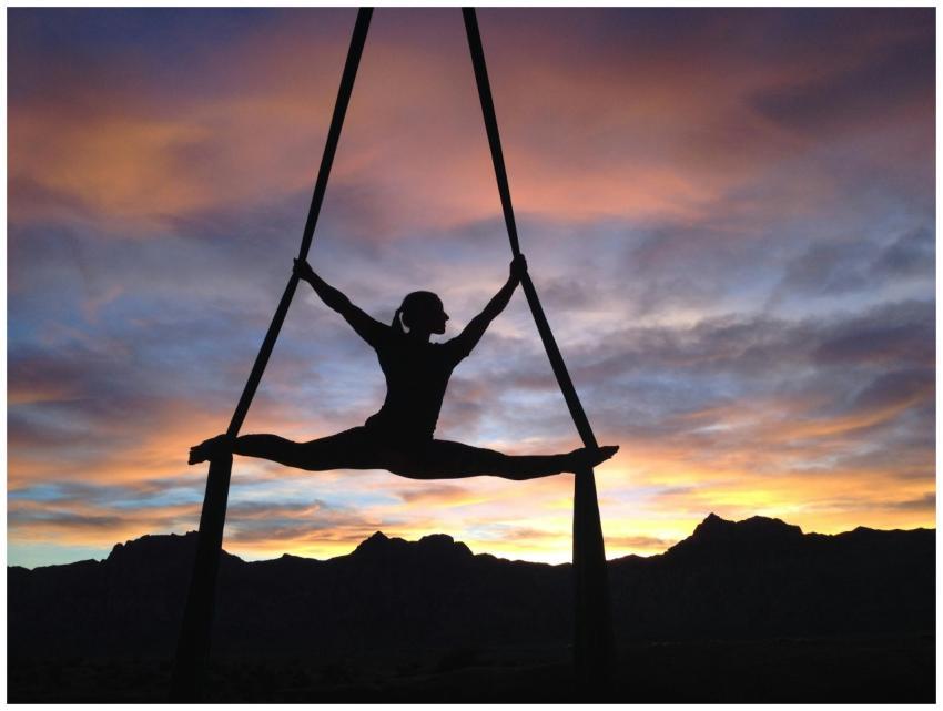 Silhouette of a woman practicing aerial yoga again