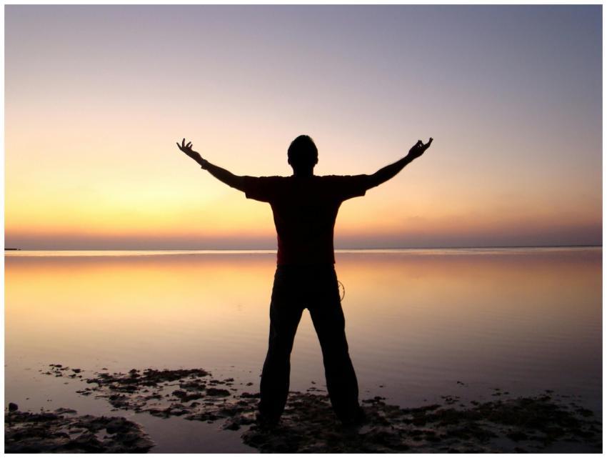 A person joyfully embracing the sunrise over a cal
