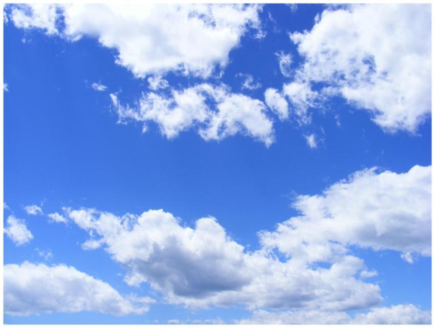 Vibrant cumulus clouds adorn a clear blue sky, cre