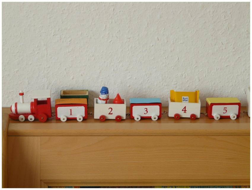 Red and white wooden toy train with numbers displa