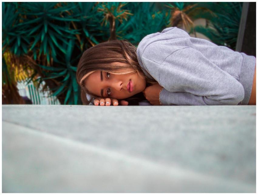 A serene portrait of a young woman relaxing outdoo