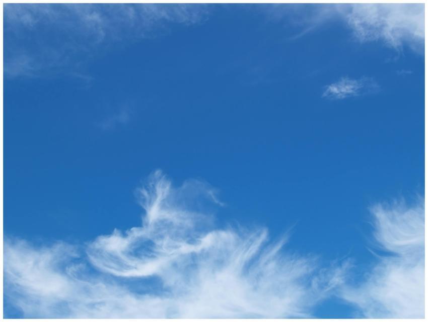 Clear blue sky with soft, fluffy white clouds form