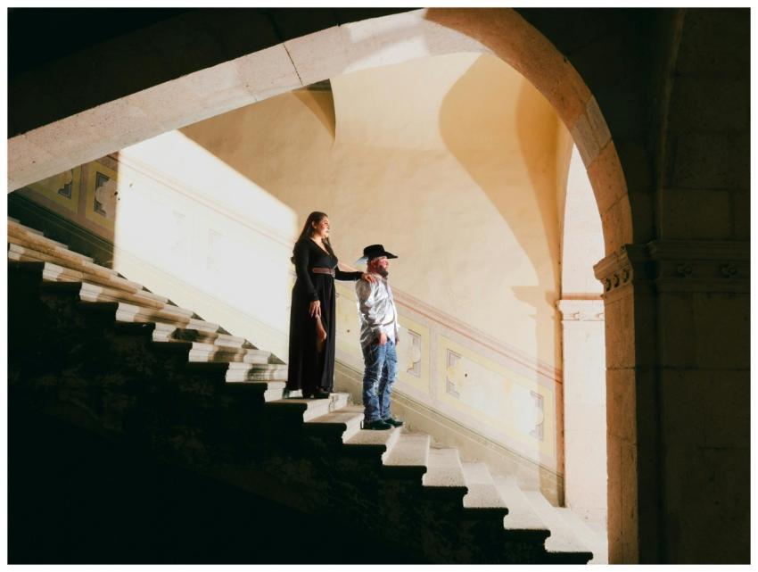 An elegantly dressed couple on a historic staircas