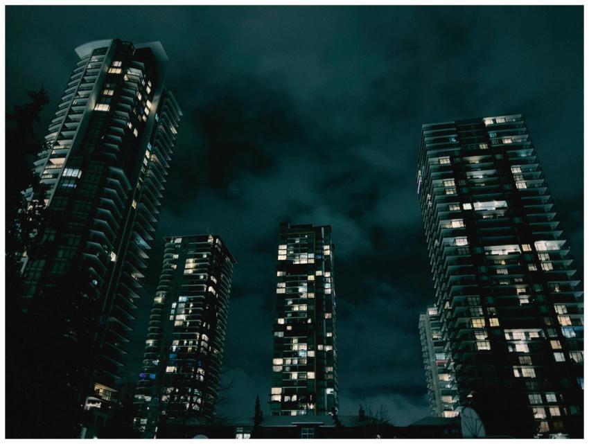 Illuminated skyscrapers towering against a dark, c