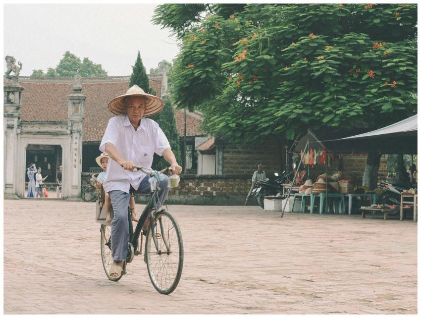 Elderly man rides a bicycle in a traditional Hà Nộ