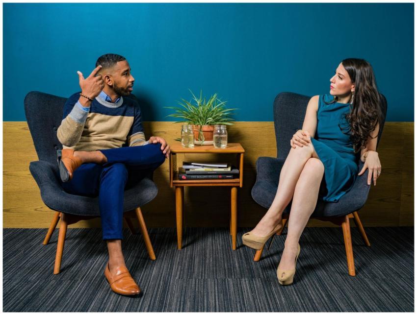 Two professionals in business attire engage in a t