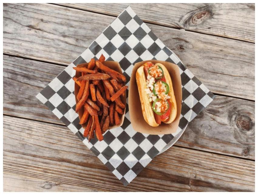 Flat lay of a gourmet hot dog with fresh toppings