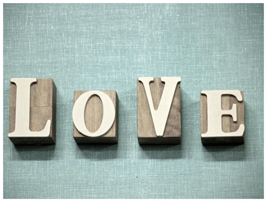 Wooden block letters spelling 'love' on a textured