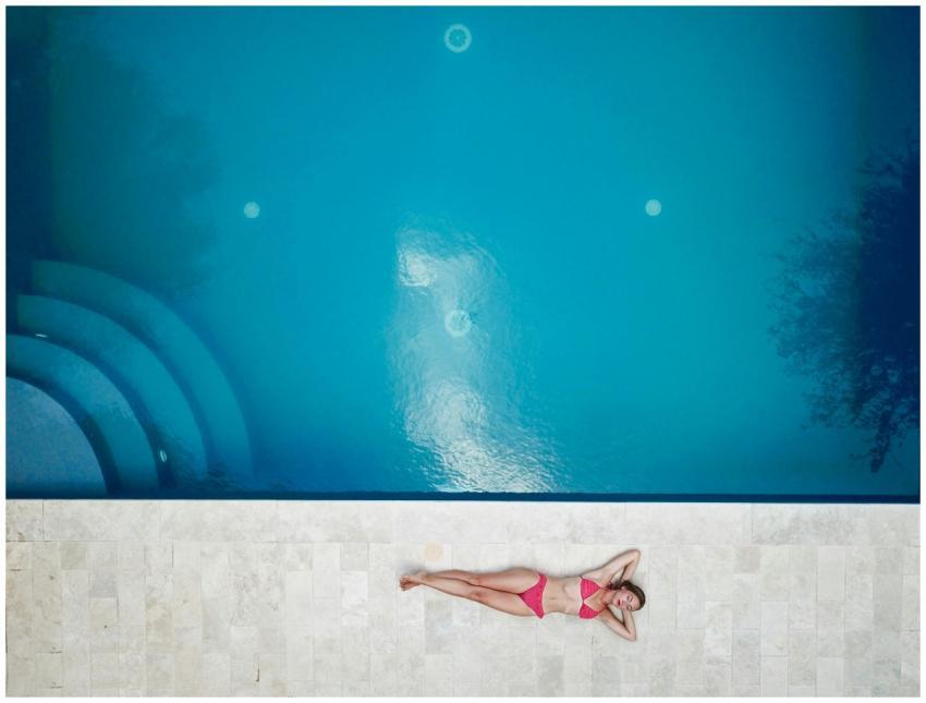 Bird's-eye view of a woman in a pink bikini relaxi