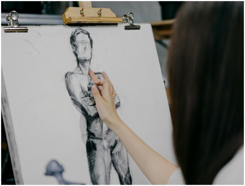 A focused artist sketching a human figure on canva