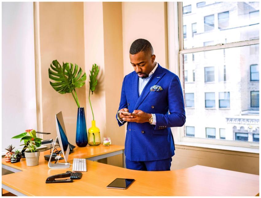 Businessman in a blue suit using a smartphone at h