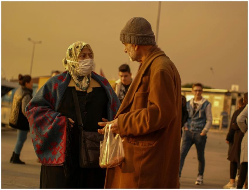 Two adults in an urban setting at twilight, speaki
