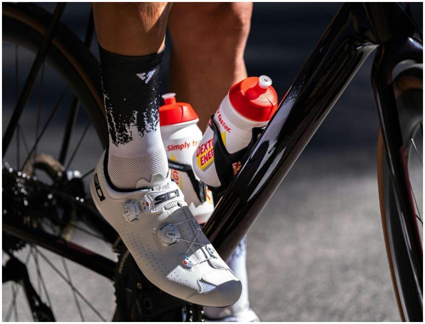 Cyclist's shoe on pedal with energy drink bottles