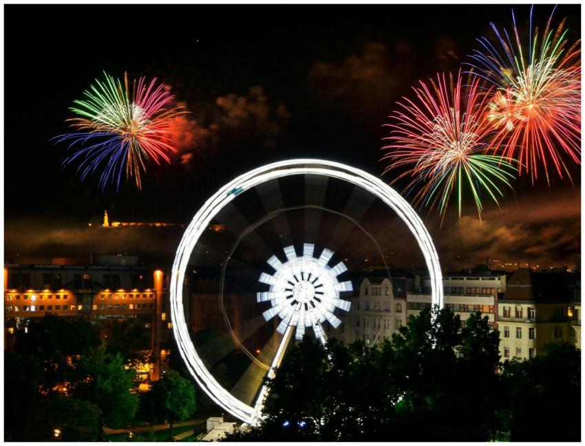 Colorful fireworks light up the sky over a Ferris