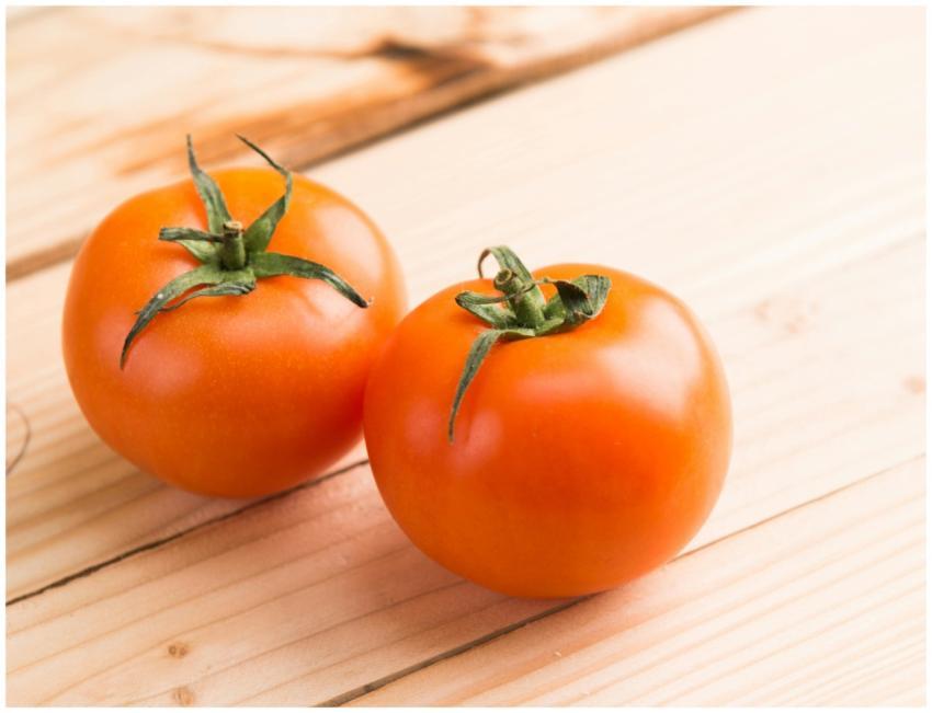 Close-up of two fresh tomatoes on a wooden table r