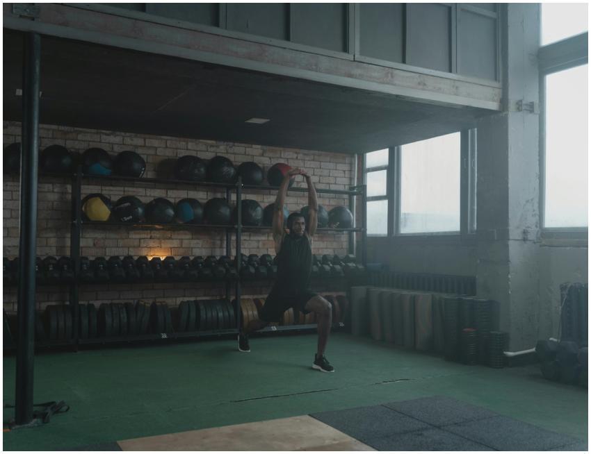 A man performing stretches in a spacious, well-equ