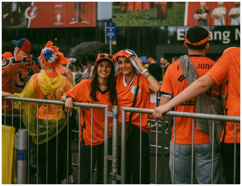 A group of soccer fans dressed in orange jerseys g