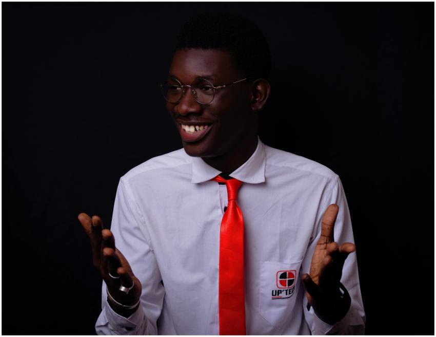 Confident young man in a white shirt and red tie,