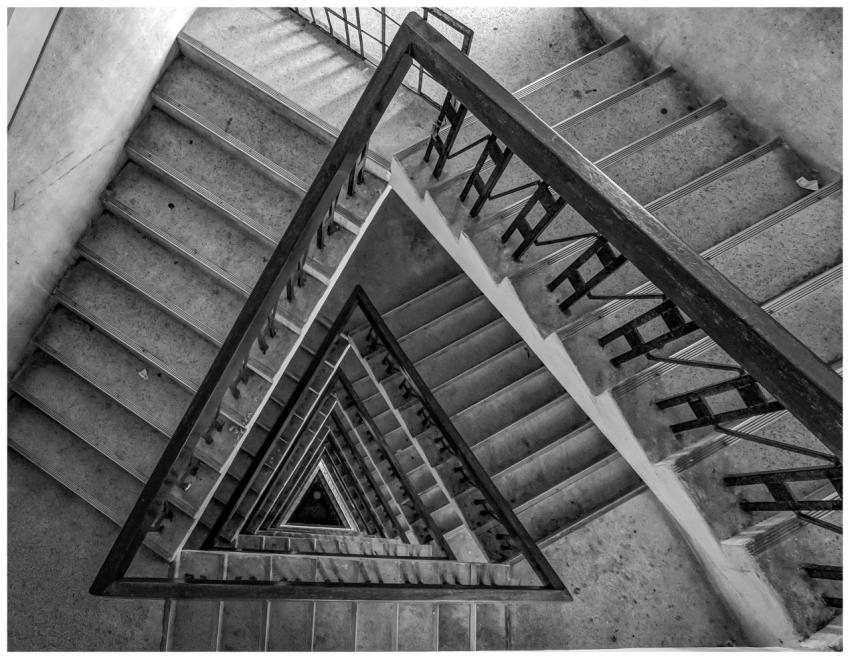 Black and white photo of a dramatic spiral stairca